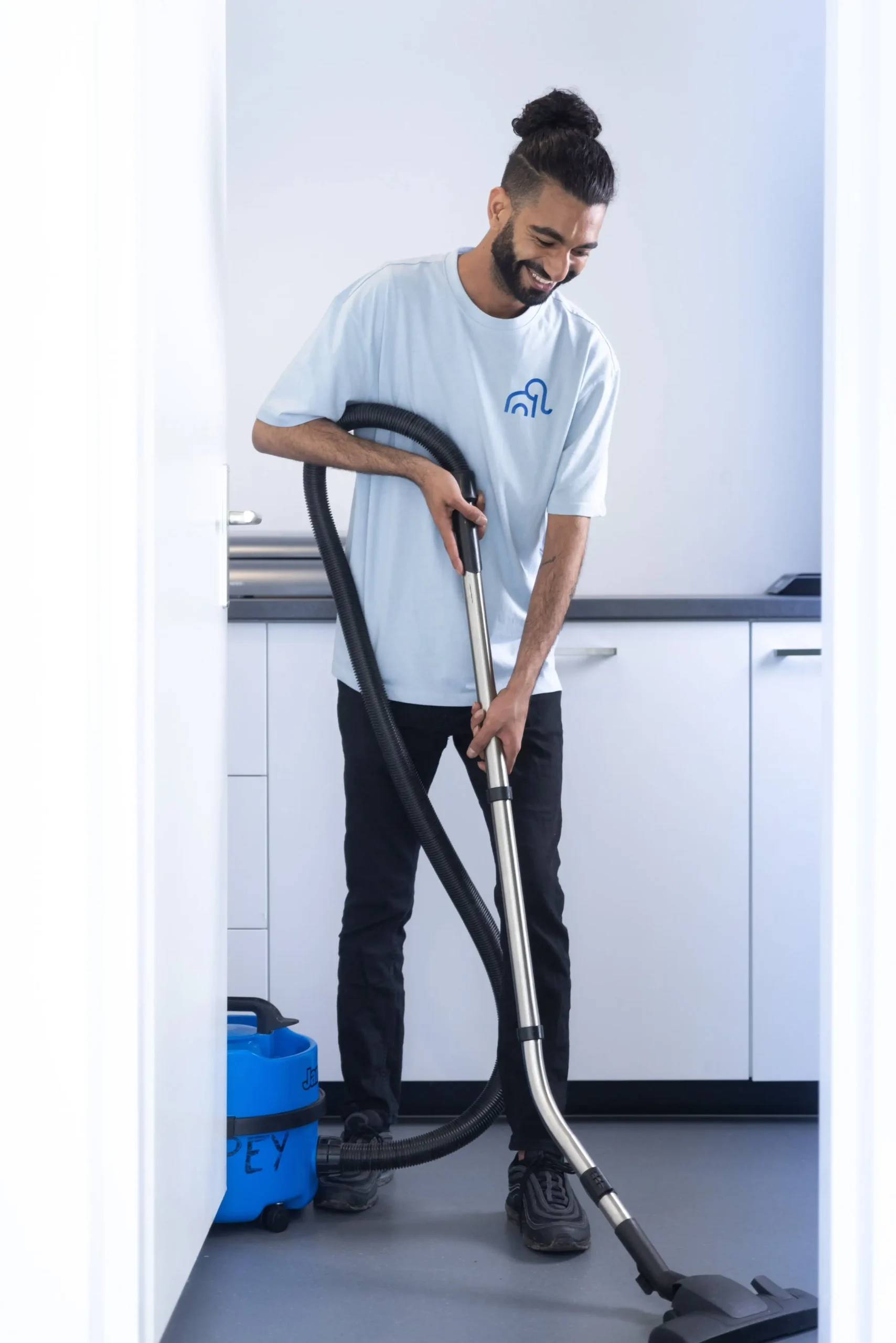 een man die aan het stofzuigen is in een kantoor